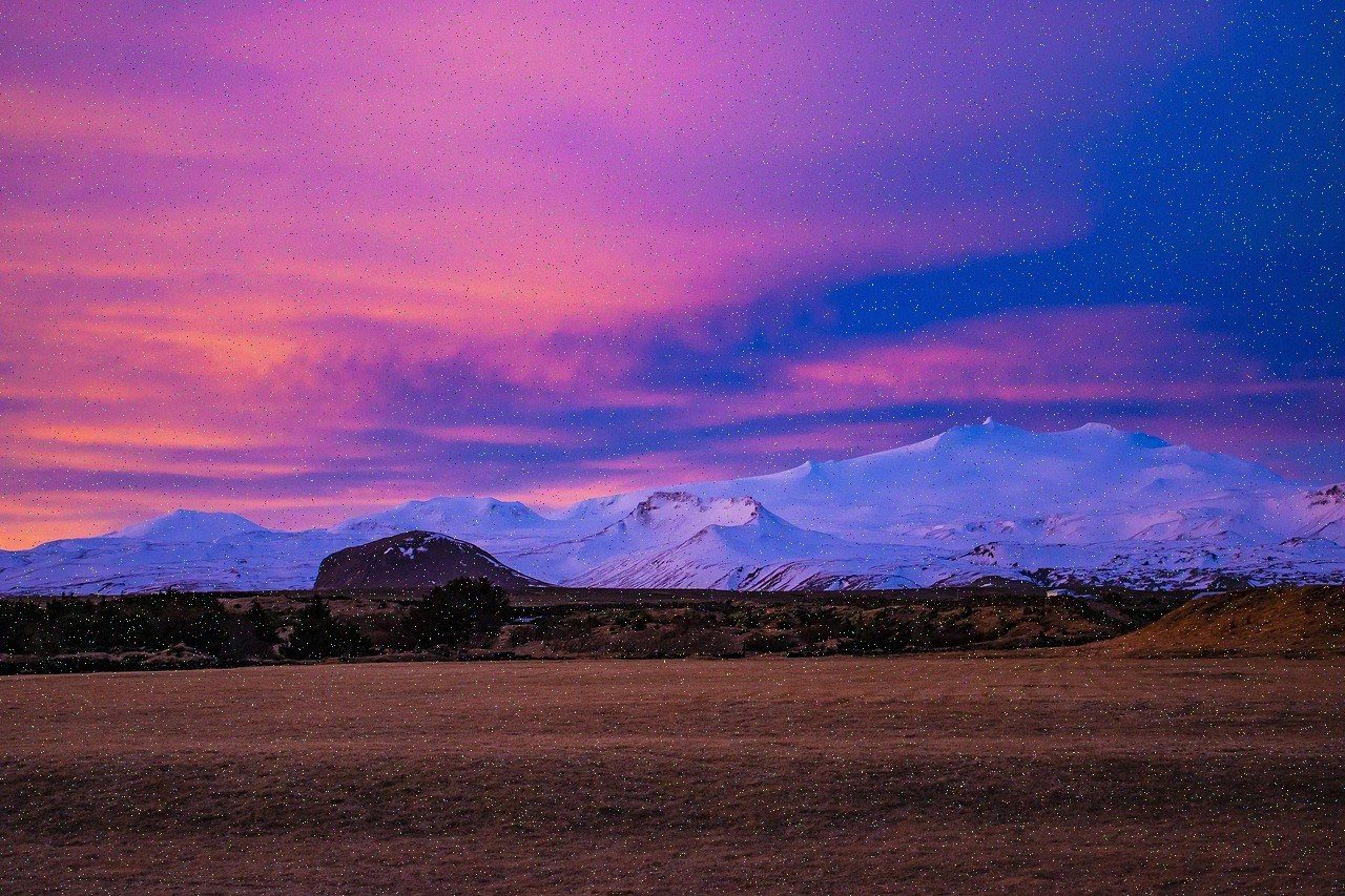 Snow-covered mountain range catching the last sunset light