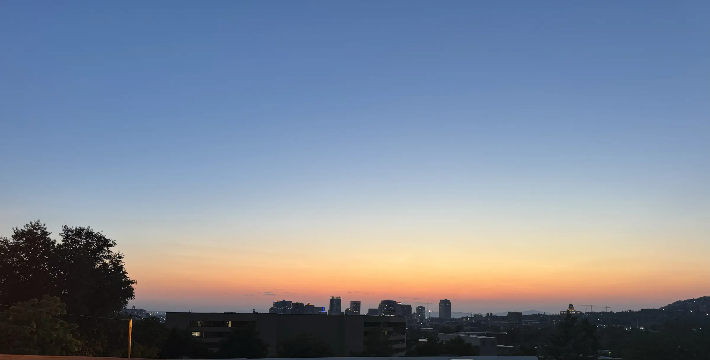 Dusk over the Salt Lake skyline: a deep blue sky fading to a thin amber band along the horizon